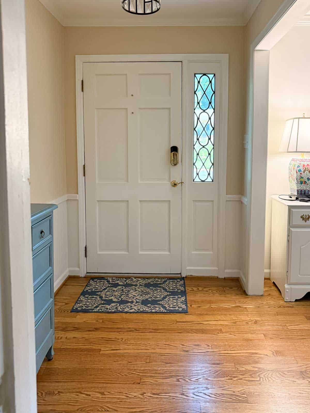 view of a small foyer with beige walls and a white front door with a sidelight