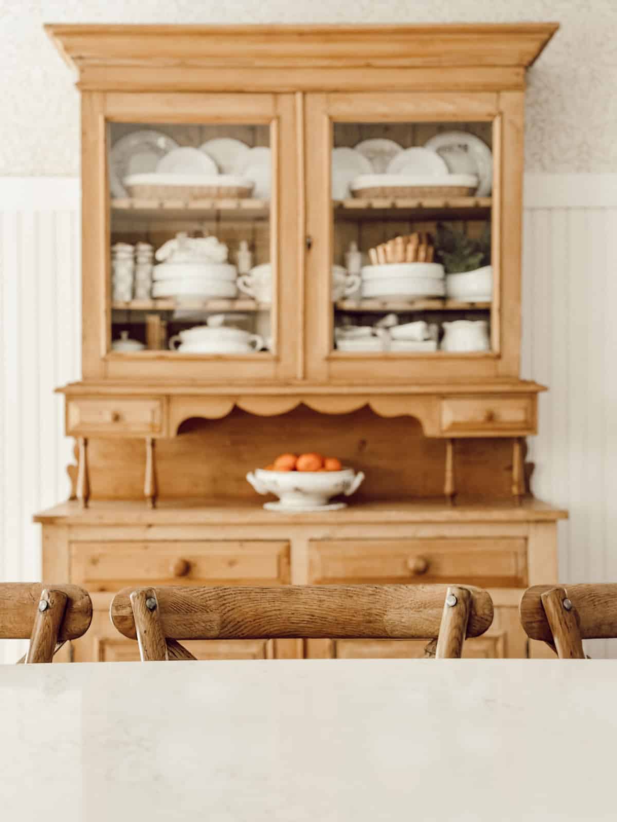 pine dish cabinet filled with white dishes