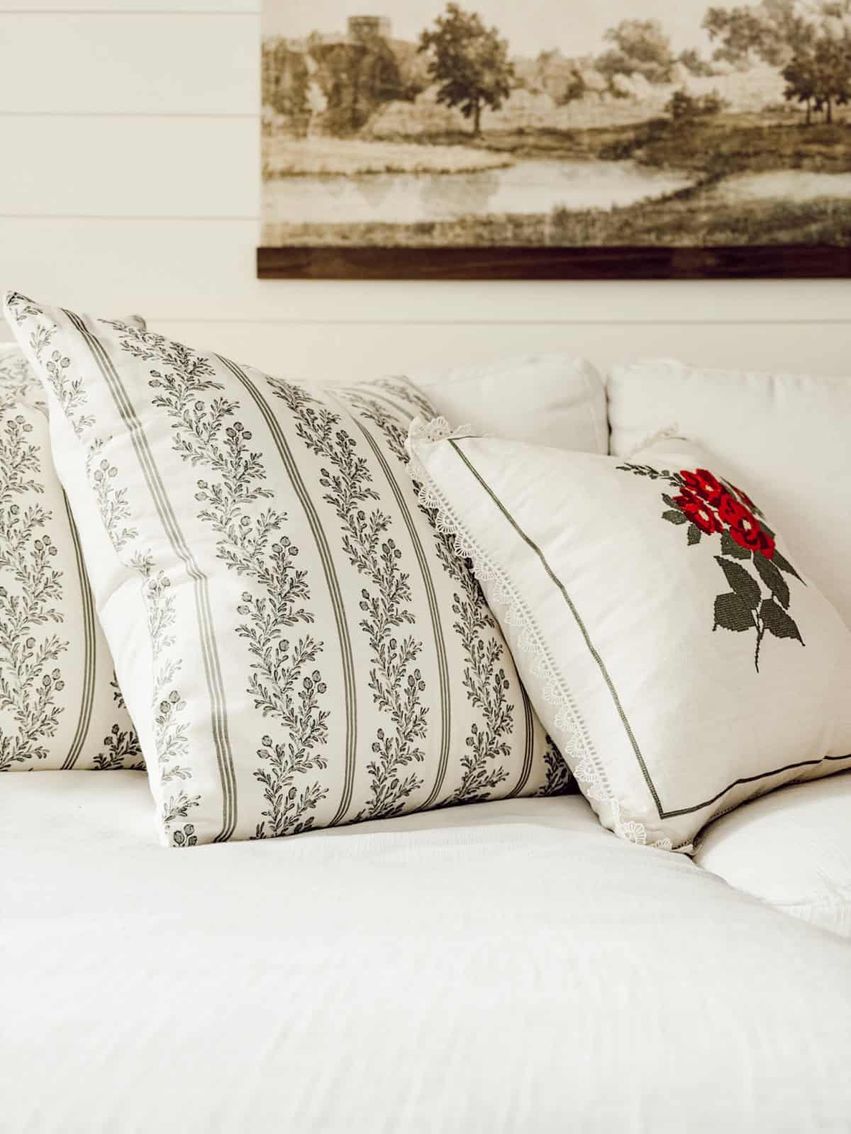 black and white print pillows and a floral embroidered pillow on a white sofa