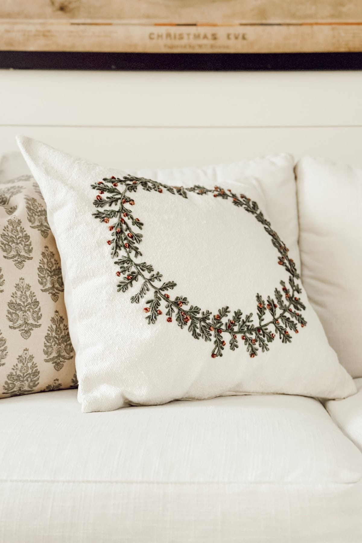 white throw pillow with embroidered wreath