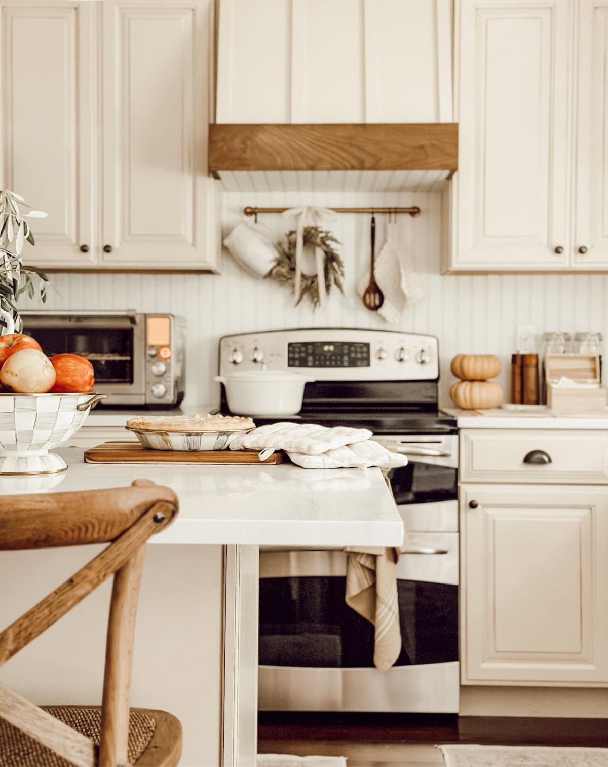 kitchen with white cabinets, and a beadboard backsplash decorated with fall decor