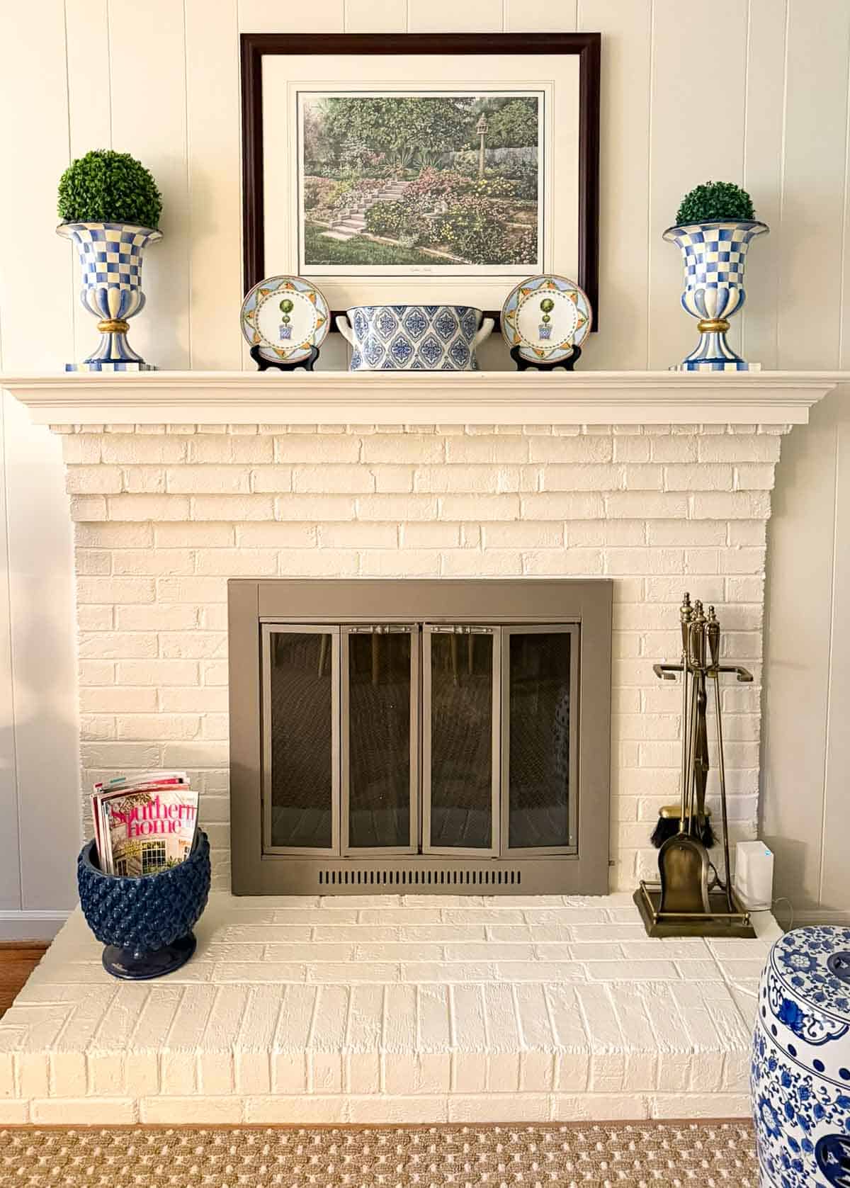 white brick fireplace decorated with blue and white accessories