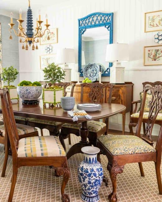 pair of traditional style dining chairs facing one another with blue, yellow and white fabric seats