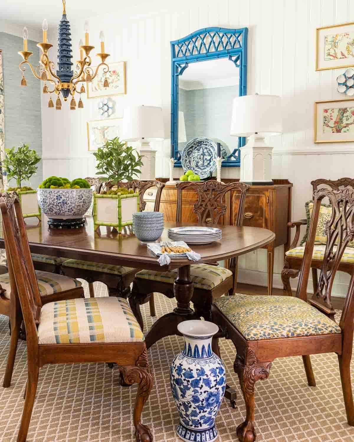 pair of traditional style dining chairs facing one another with blue, yellow and white fabric seats