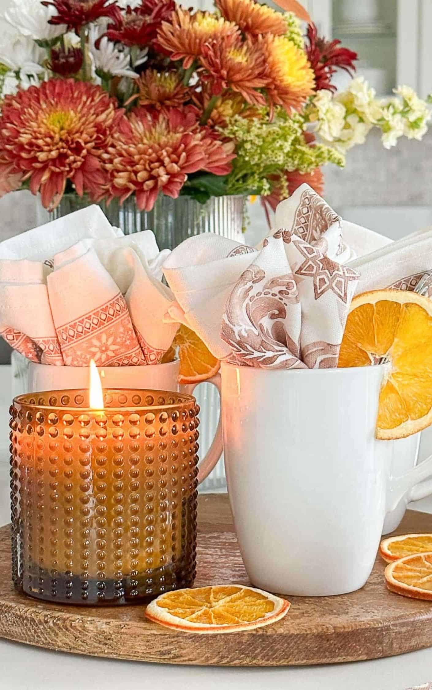 arrangement of fall colored mums in a mercury glass vase in a kitchen counter vignette