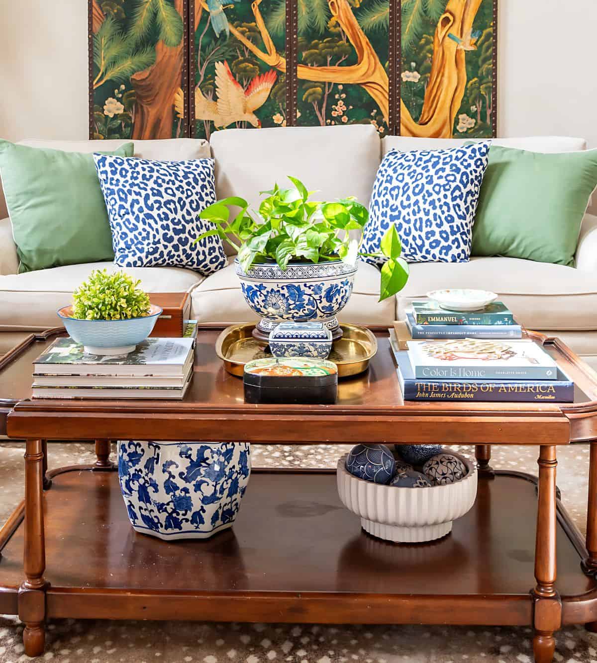 wood coffee table in front a neutral sofa decorated with blue and white chinoiserie pieces