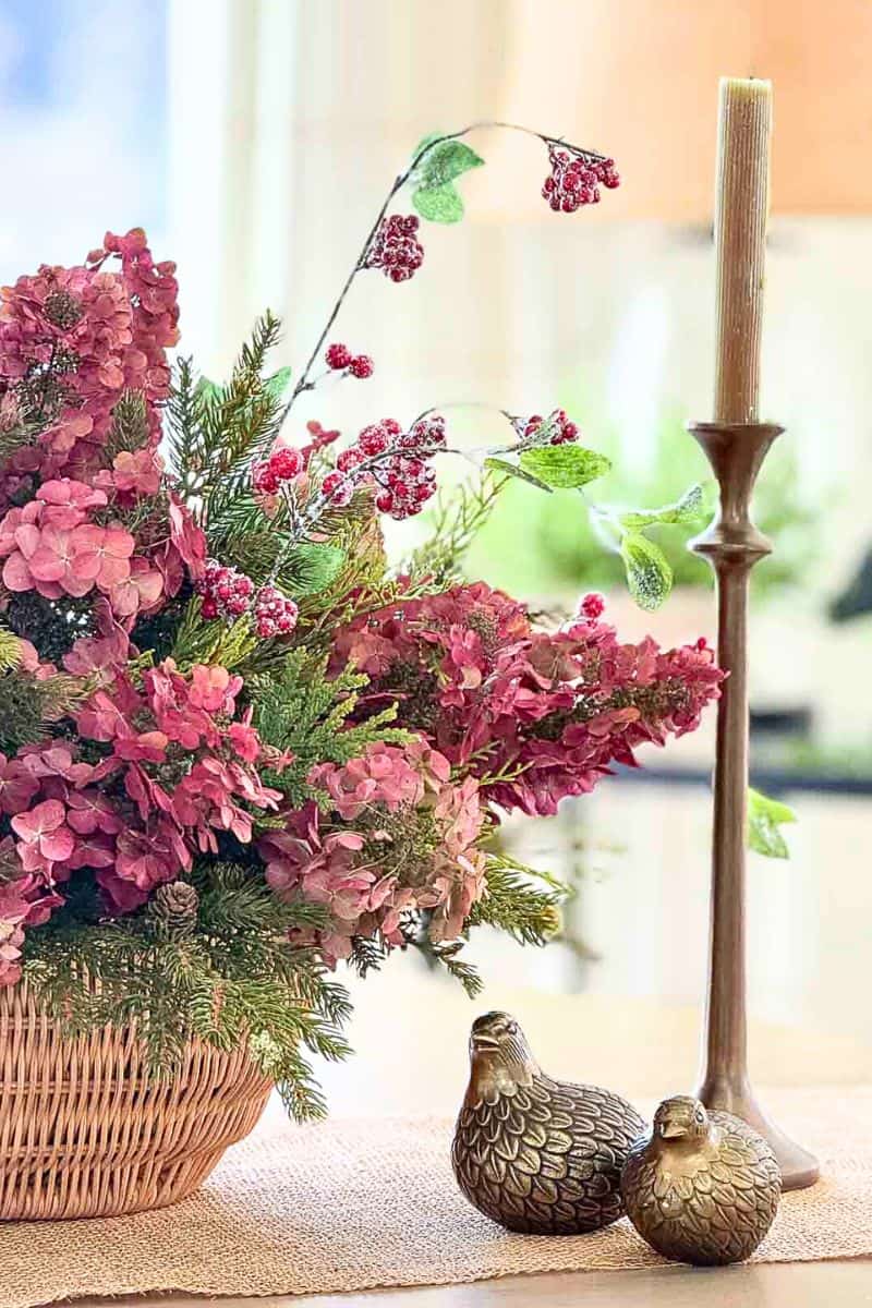 Close-up of a vibrant flower arrangement with pink hydrangeas, greenery, and decorative birds, perfect for seasonal home decor.
