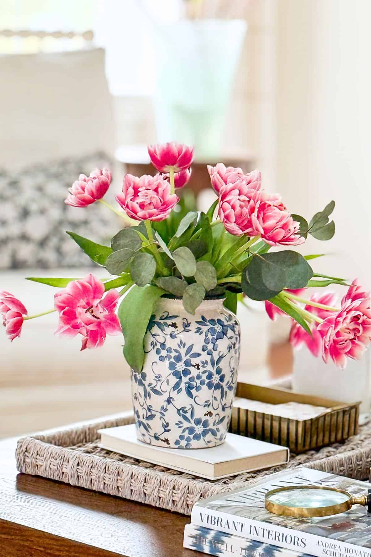 blue and white vase filled with pink flowers