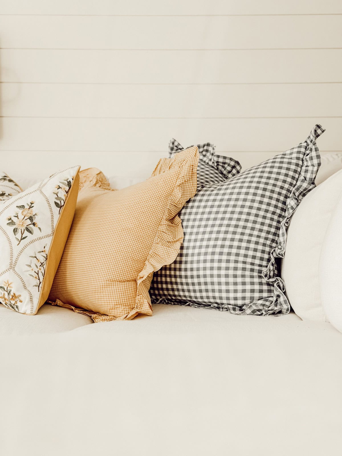 three throw pillows with different patterns in a row on a sofa