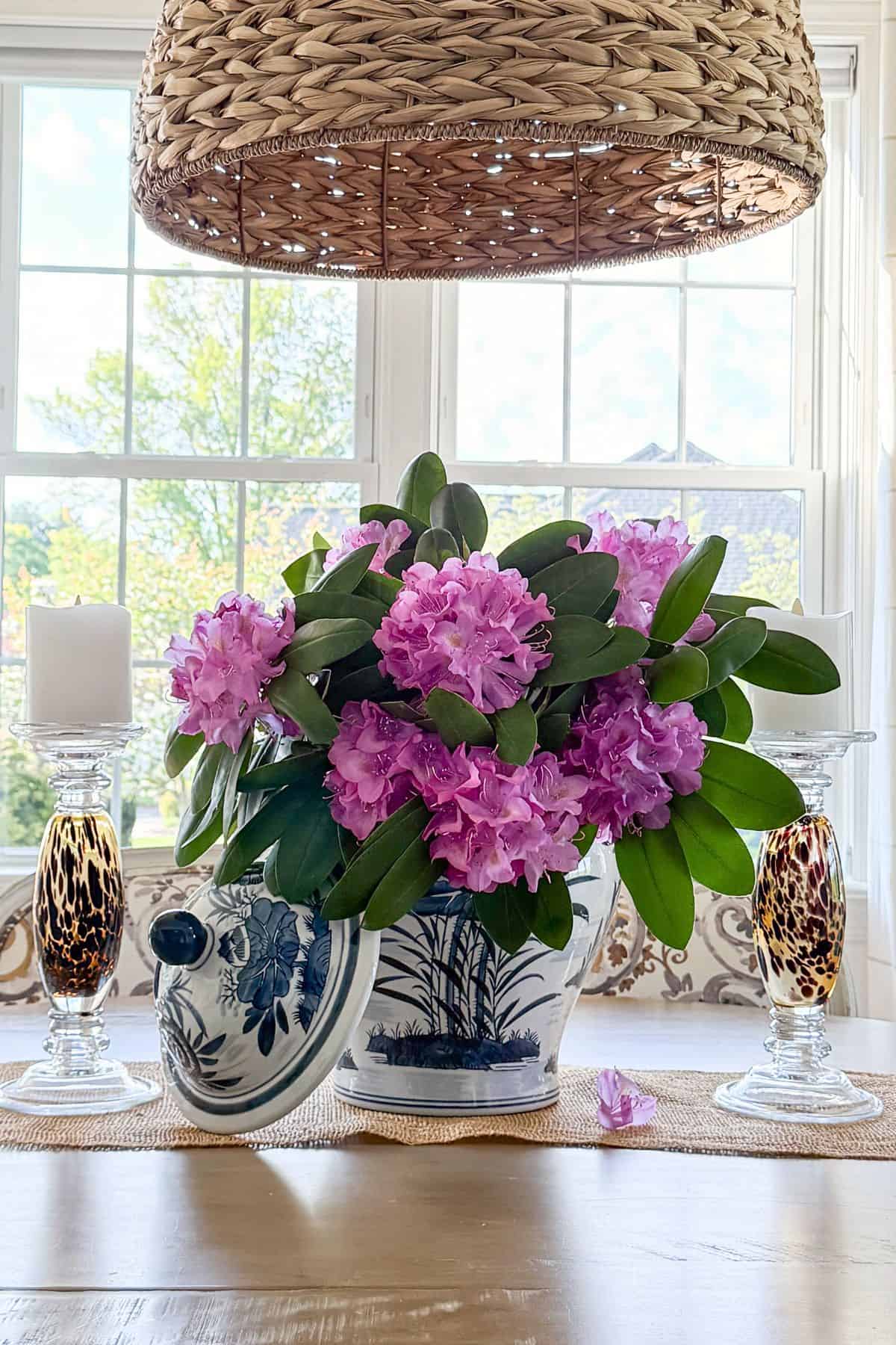 arrangement of rhododendrons in a blue and white vase on a table