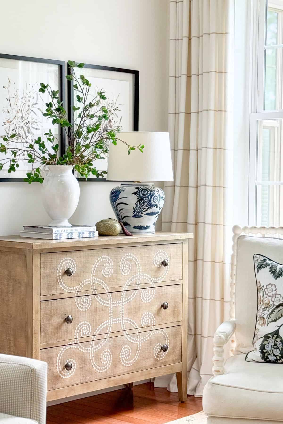 blue and white accessories on a beige chest with curlicue design