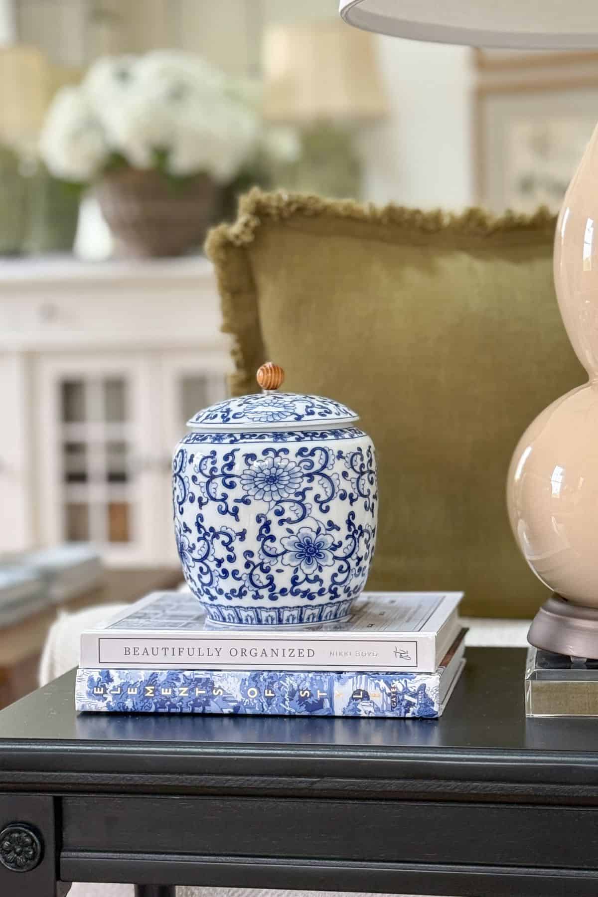 blue and white chinoiserie urn on top of a stack of coffee table books