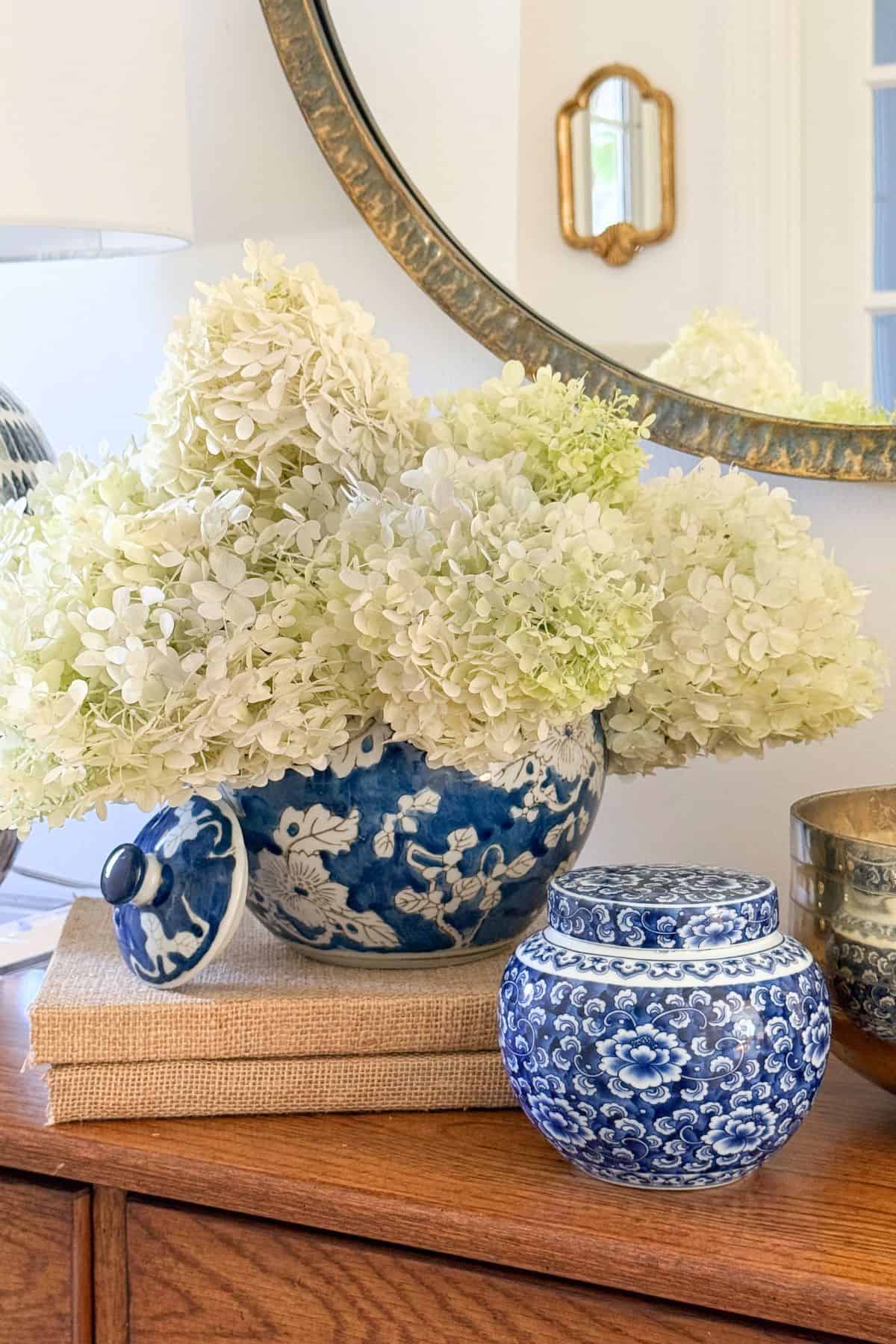 blue and white vase filled with cut white hydrangeas