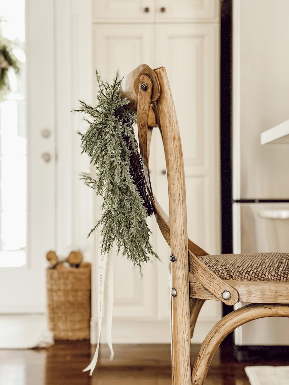 cedar Christmas wreath hanging on the back of a dining chair