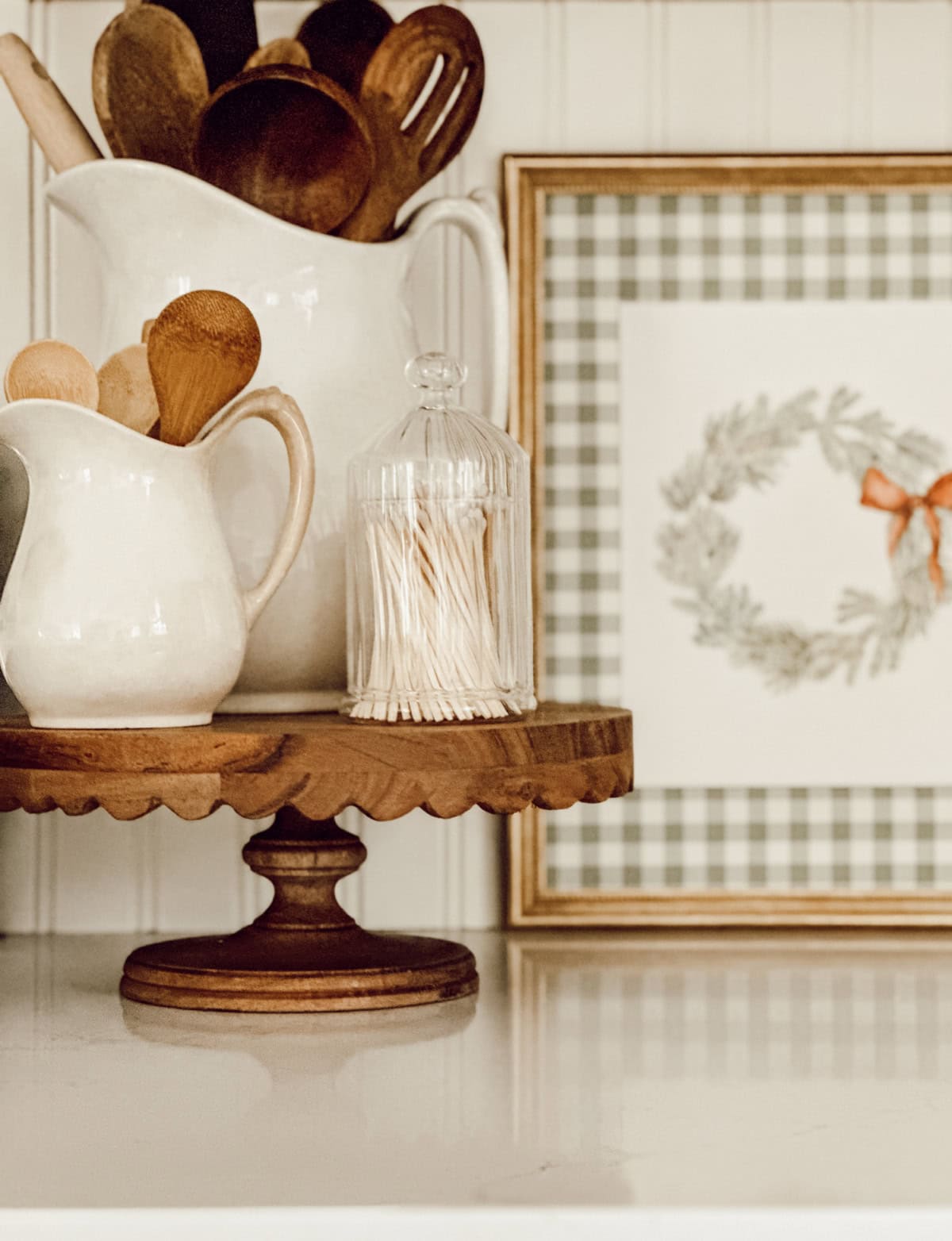 collection of wooden spoons in a white pitcher on a wooden pedestal