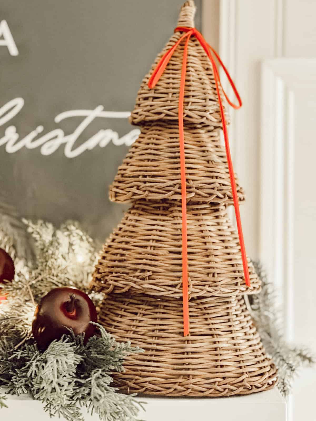 wicker Christmas tree topped with a simple orange ribbon bow