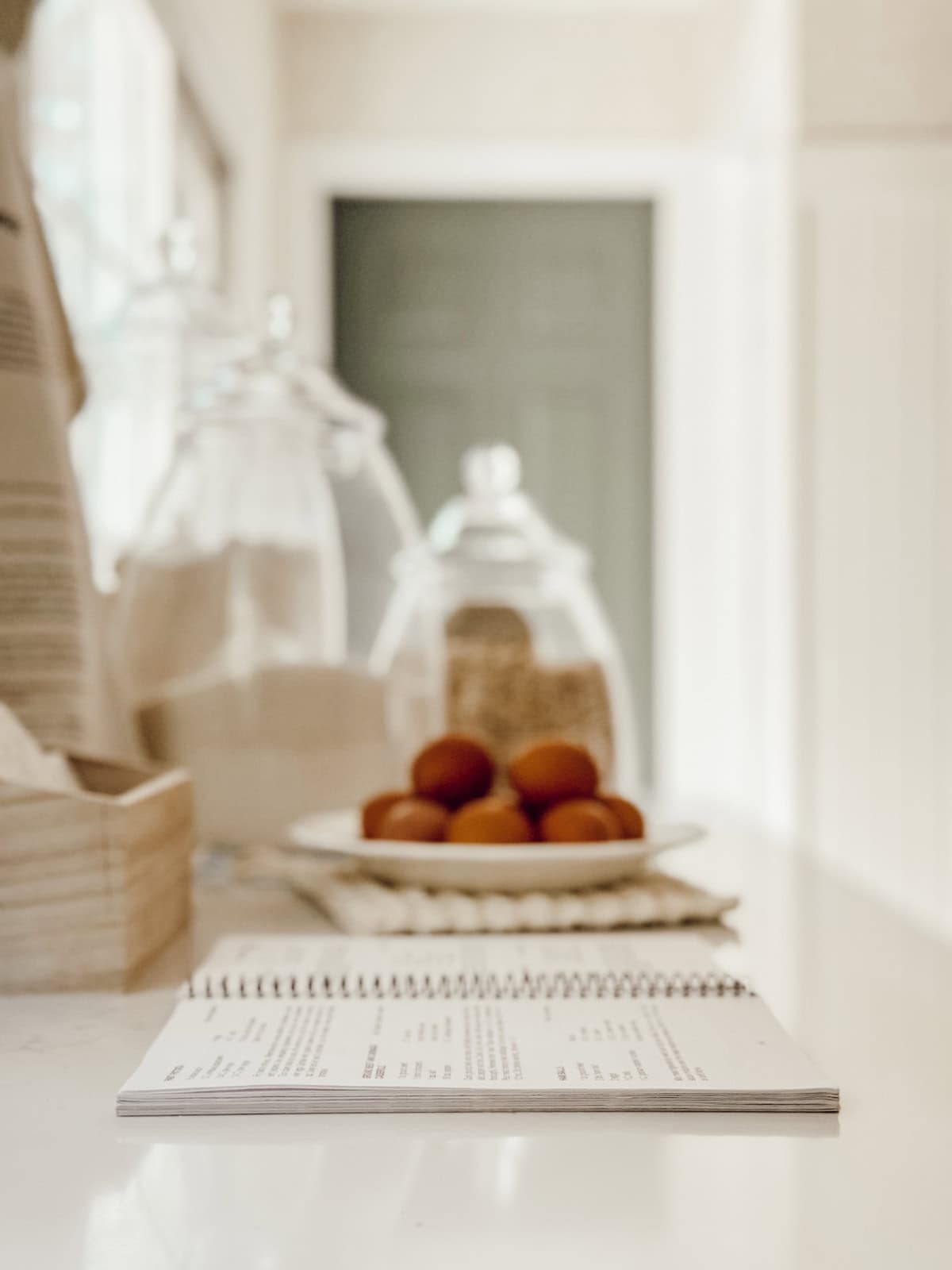 open spiral bound book lying on a counter beside a plate of eggs