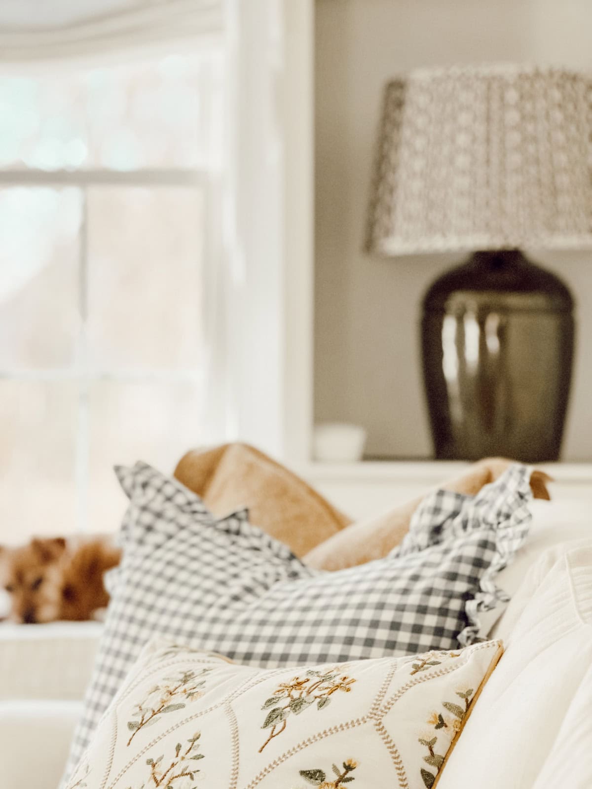 three pillows in neutral colors on a white sofa