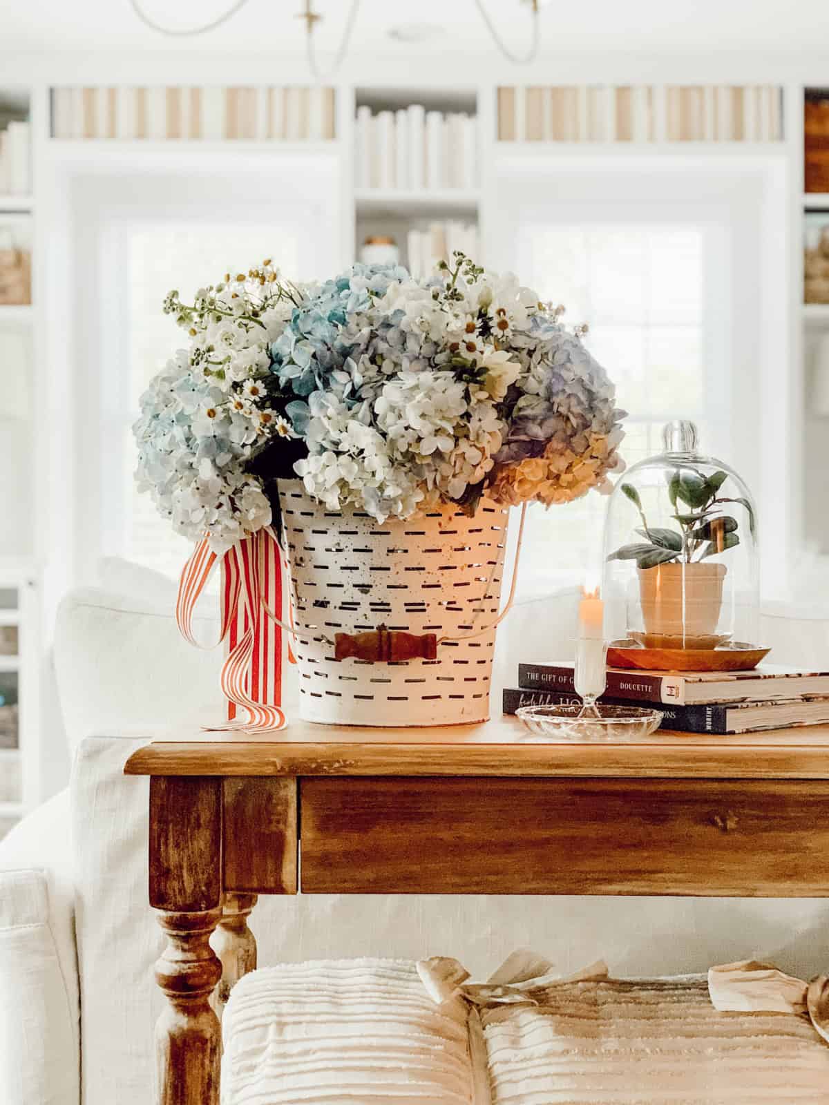 white bucket filled with blue and white hydrangeas and daisies