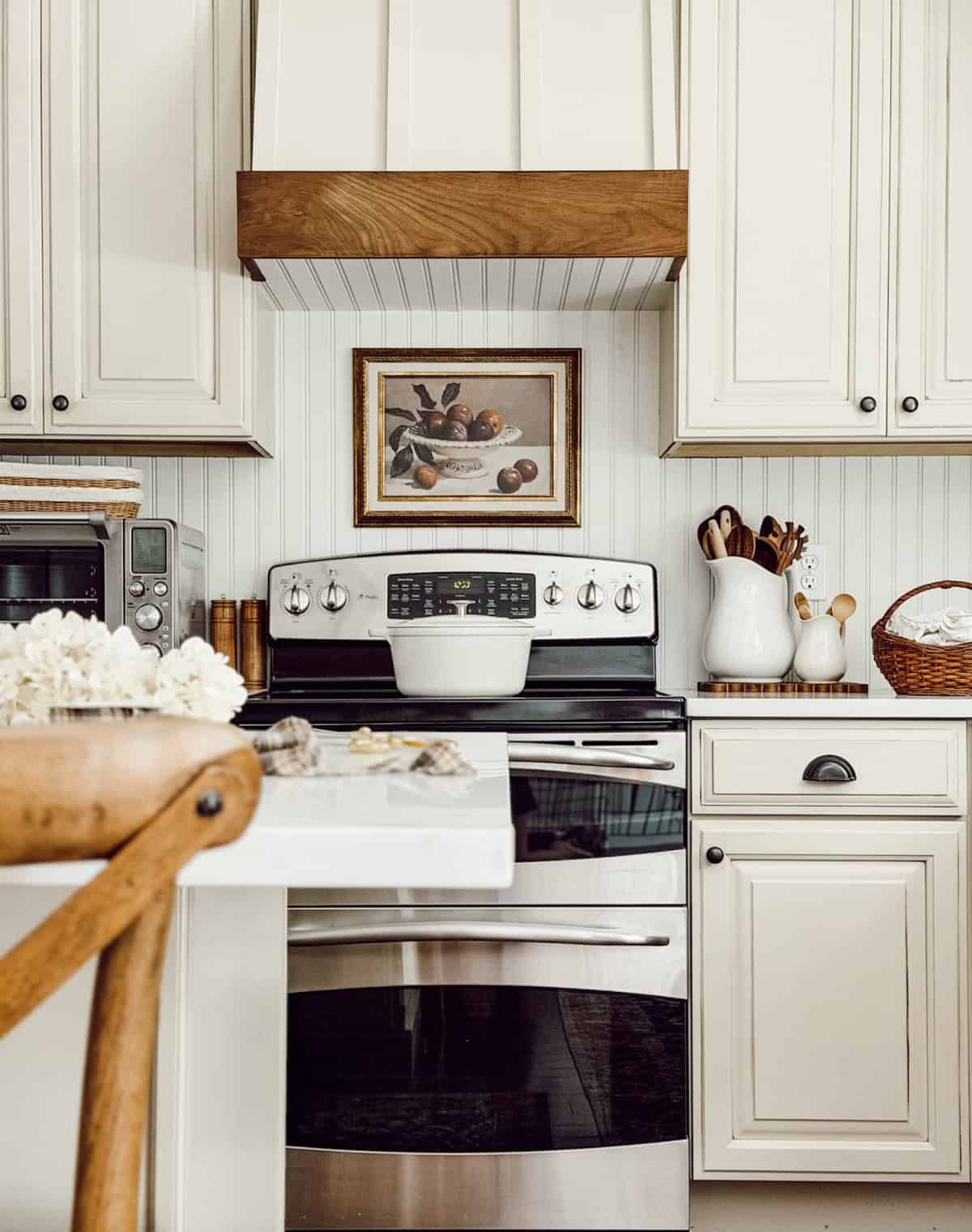 view of stove in a white kitchen with wood accents