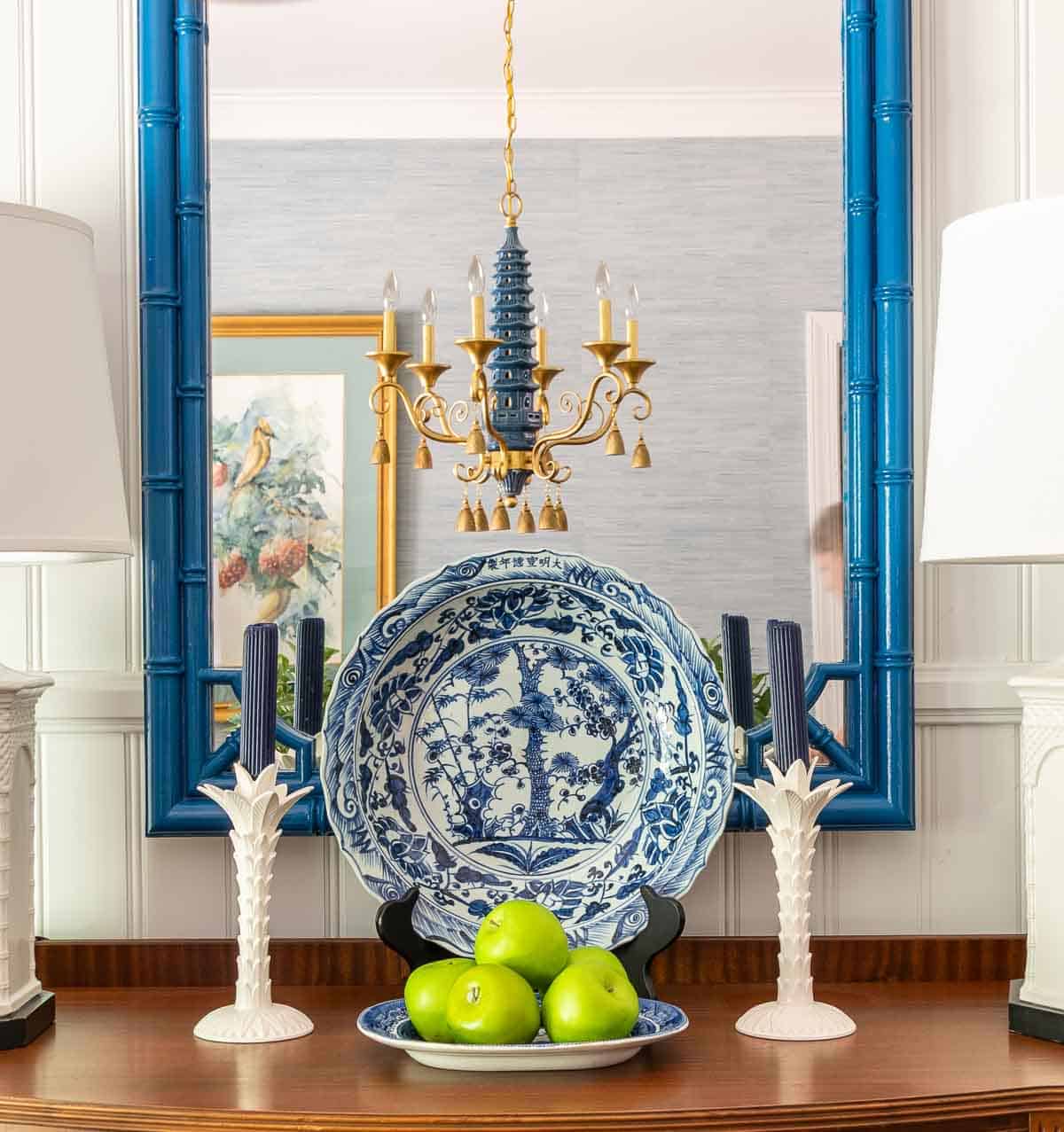 blue and white chinoiserie decor on a wooden sideboard with white buffet lamps