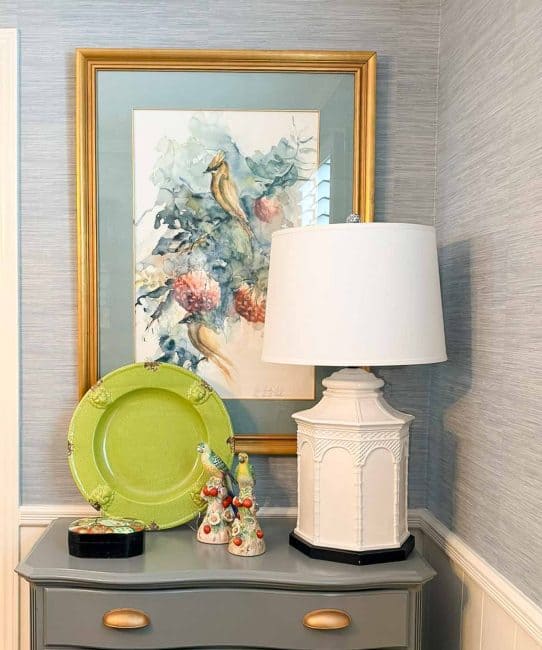 white lamp on gray chest with traditional style artwork and accessories