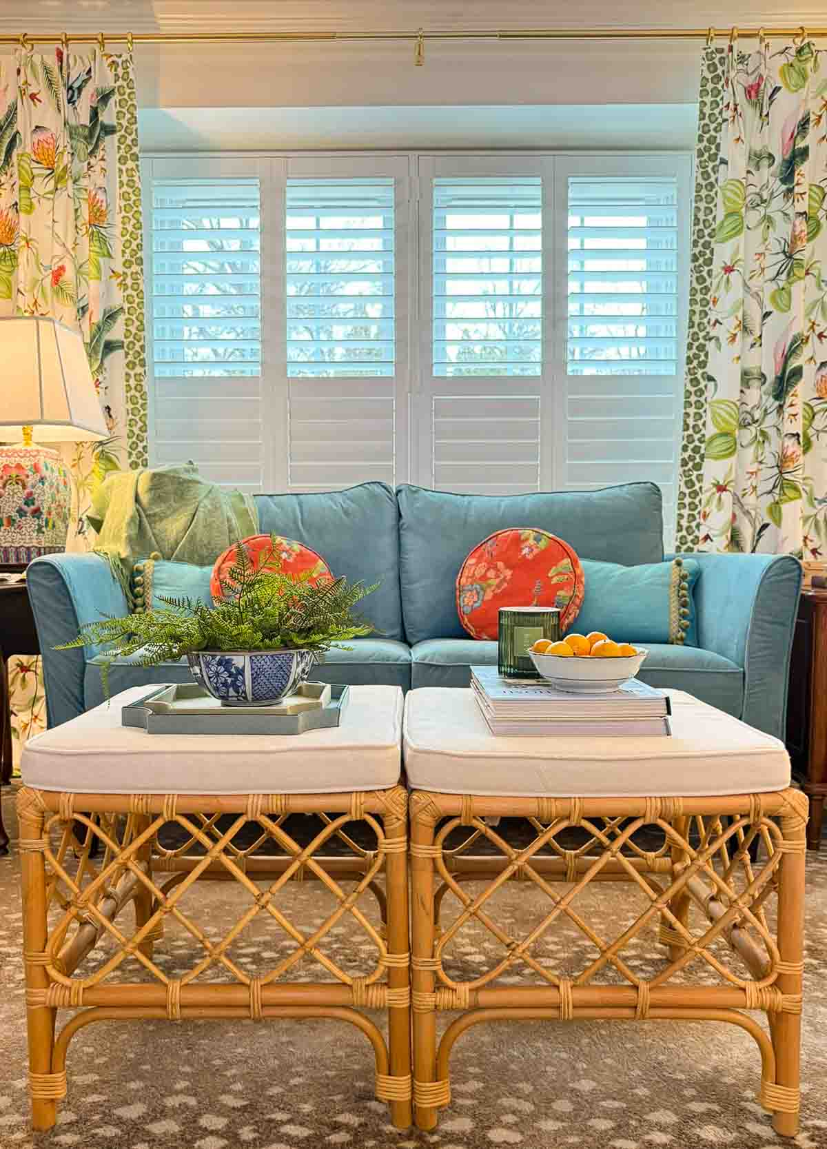 turquoise blue velvet loveseat with a pair of rattan footstools