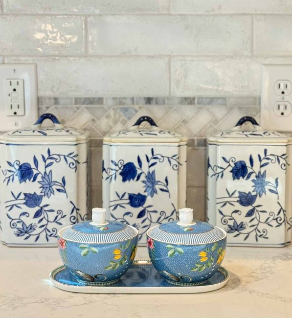 trio of blue and white canisters and a set of blue sugar bowls on a white kitchen counter