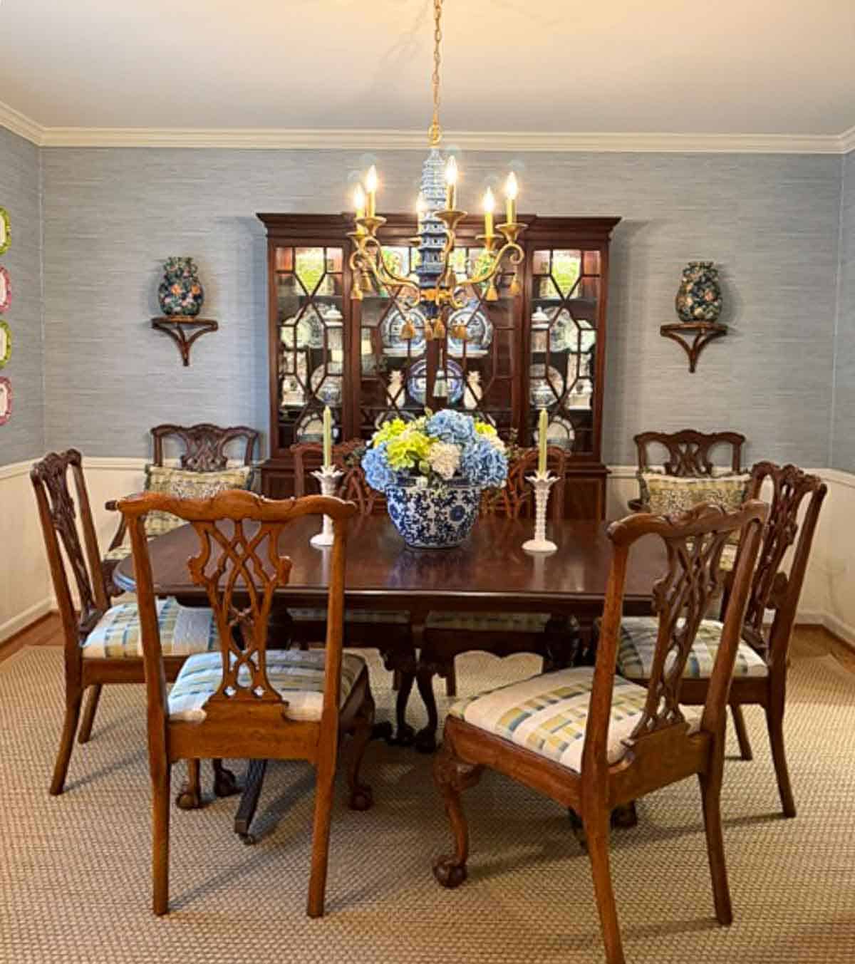Dining room with blue grasscloth wallpaper and traditional wood furnishings