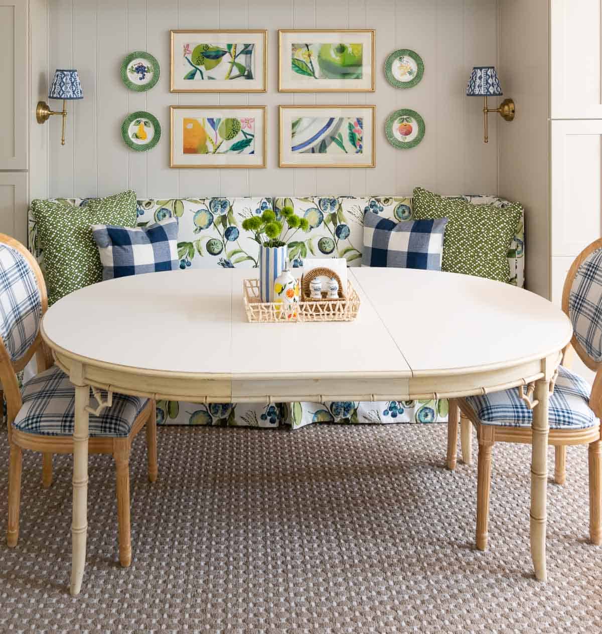 oval kitchen table in front of a colorful banquette bench