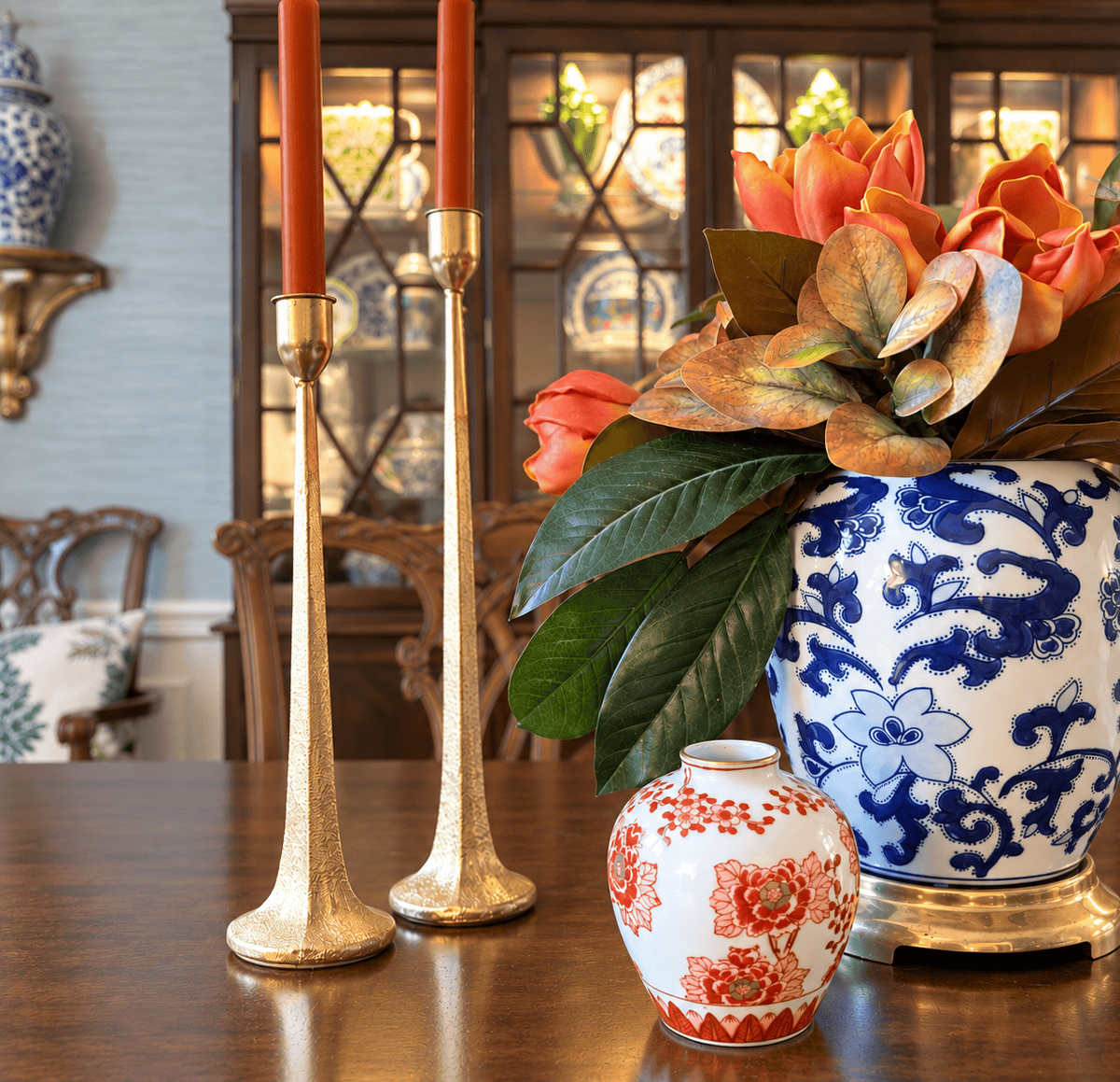 fall florals in a blue and white chinoiserie vase beside brass candlesticks