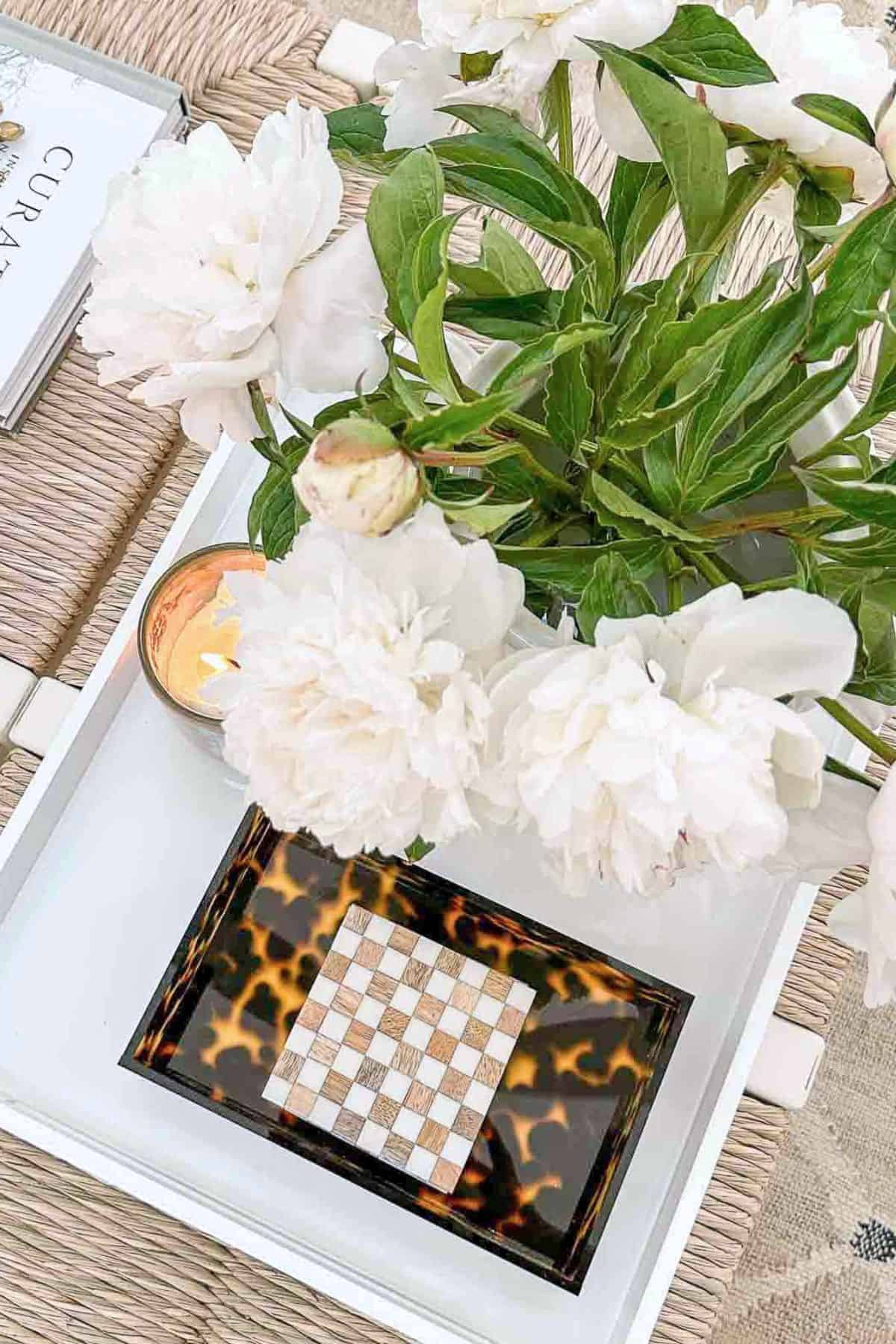 overhead view of white flowers on a white coffee table tray