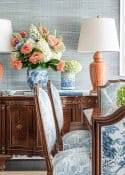 Colorful floral centerpiece with vases on vintage wooden sideboard for elegant home decor.