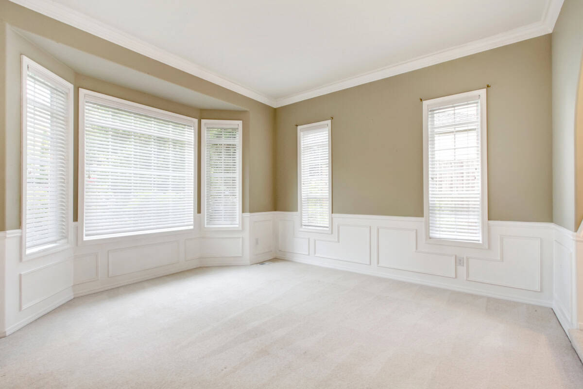 empty living room with beige walls and off white carpeting
