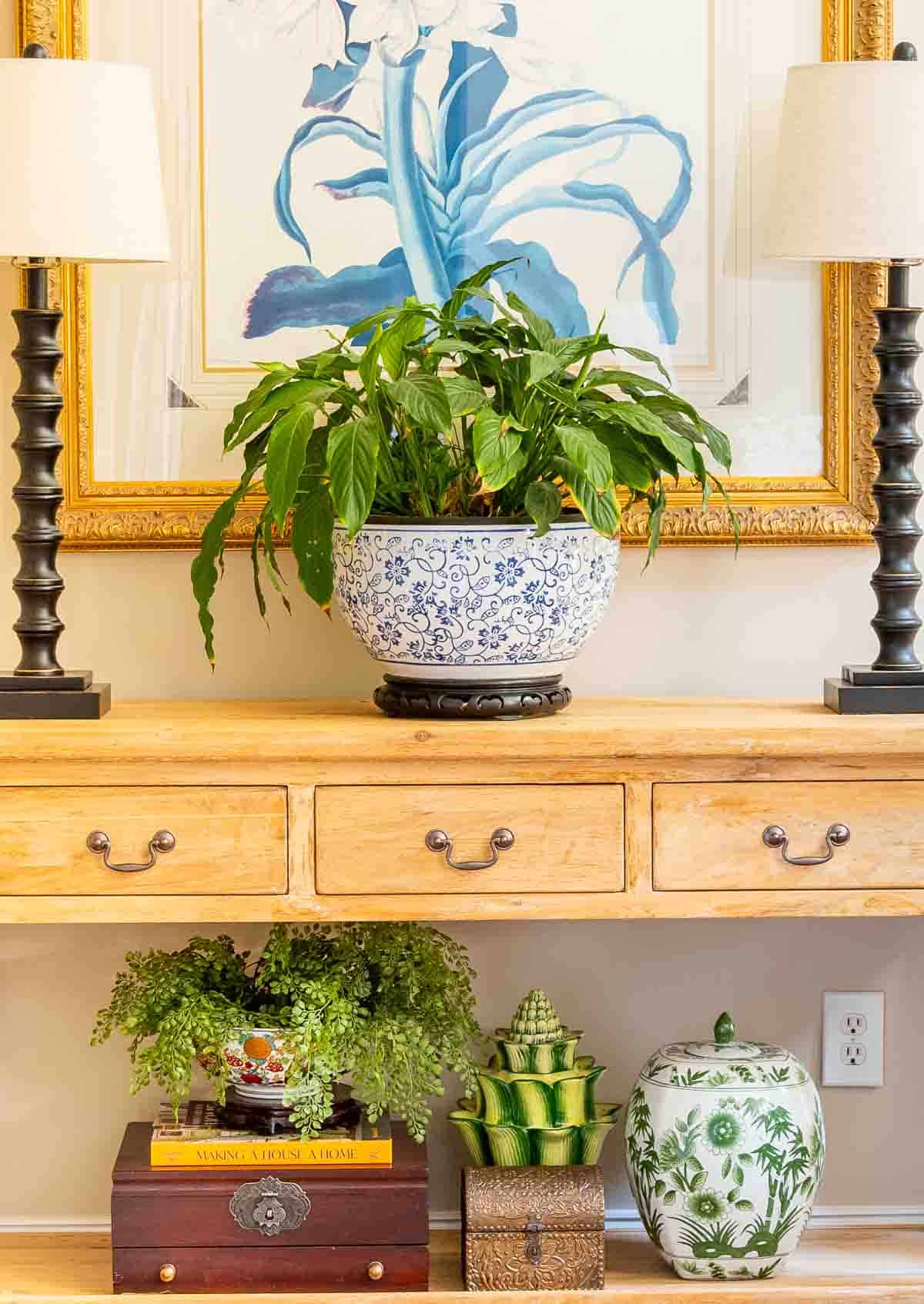 natural wood console table decorated with buffet lamps and chinoiserie accessories