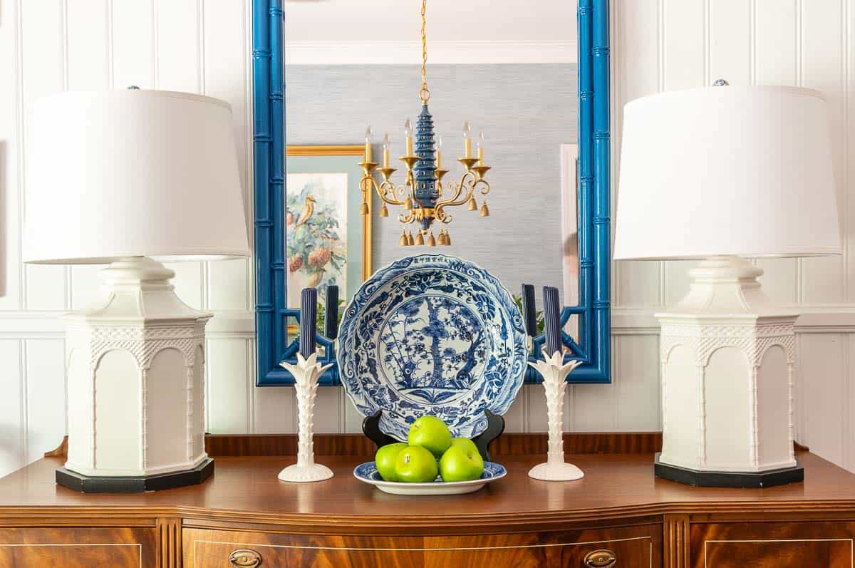 blue and white chinoiserie decor on a wooden sideboard with white buffet lamps